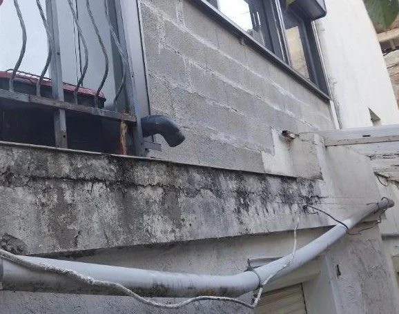 Rejet d’eau au pied du mur avec humidité sur la maçonnerie