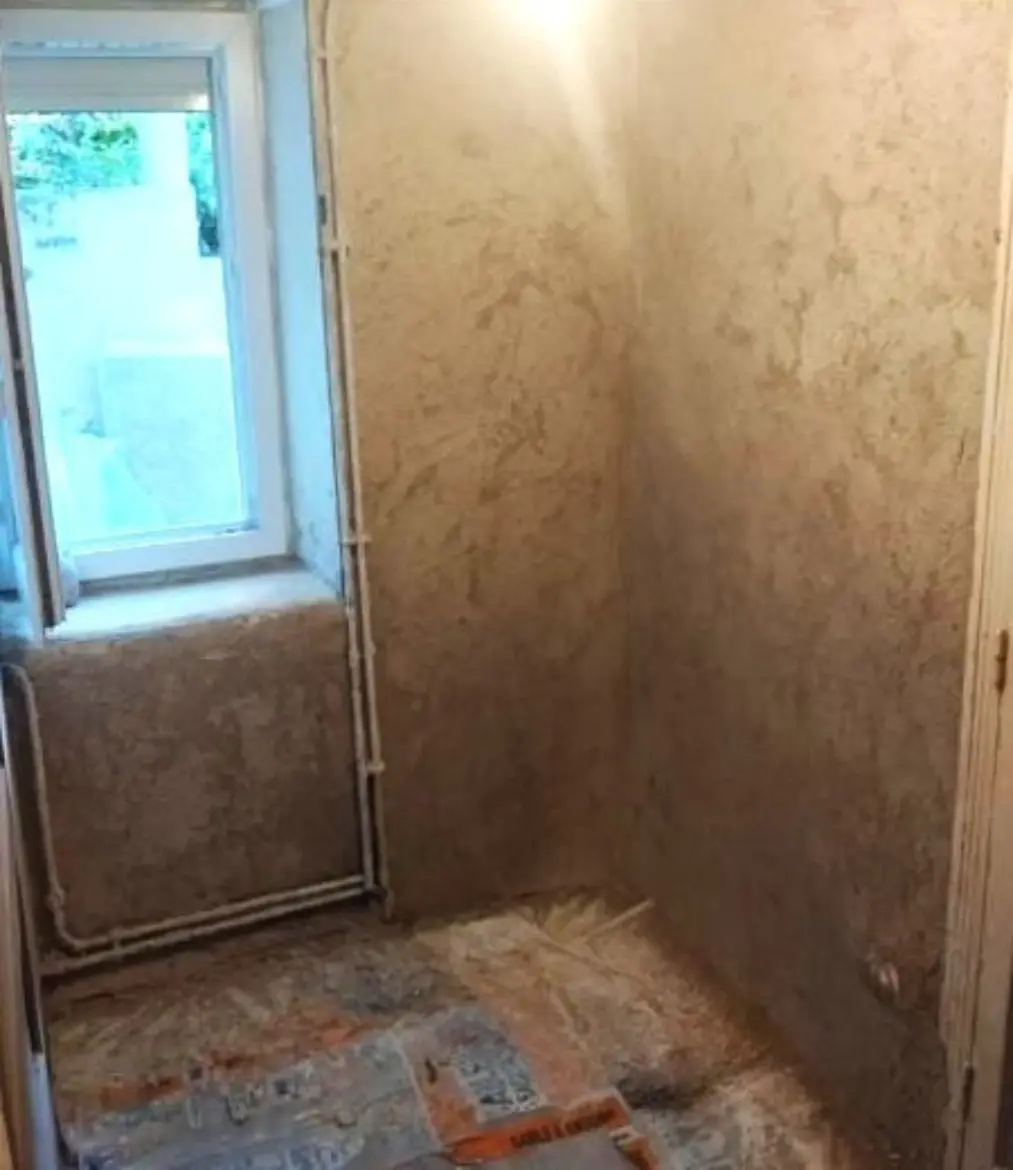 Enduit récent avec humidité persistante en pied de mur malgré des travaux réalisés