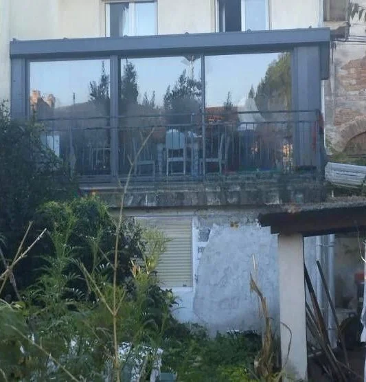 Véranda exposée au soleil avec forte surchauffe estivale, diffusant la chaleur vers les pièces de vie